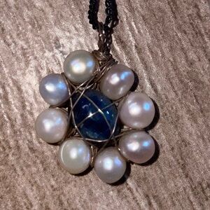 Pearl and Star Sapphire pendant wrapped in a metal cage